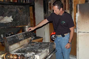 Mickey Grasso examines a kitchen range
